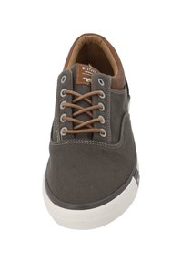Grijze canvas sneaker met bruine leren accenten, voorzien van beige veters, een ronde neus en een witte rubberen zool. Richtinggevende stiksels zichtbaar.