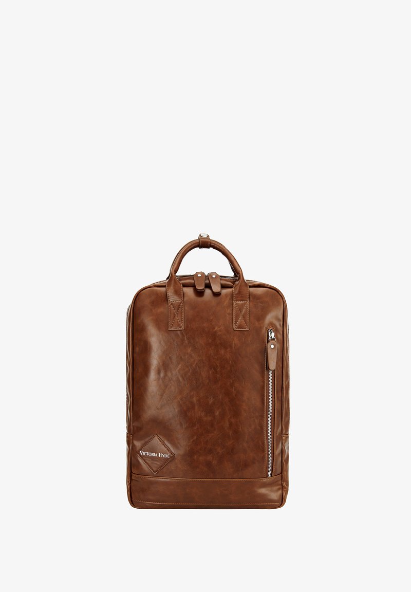 Mochila de cuero marrón con un diseño estructurado, dos asas superiores, un bolsillo delantero con cremallera y detalle de logo. Textura suave con un acabado brillante.