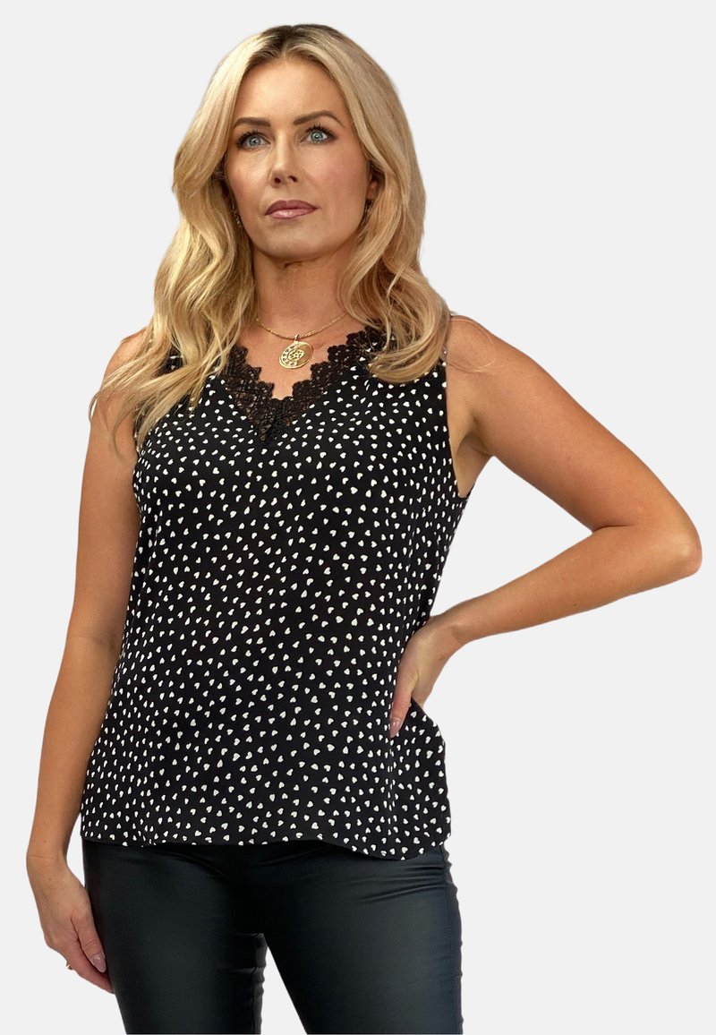 Czarny bezrękawnik z dekoltem w serek i koronkowym wykończeniem, z białym wzorem serc. Tekstura jest gładka, materiał wydaje się lekki i miękki.