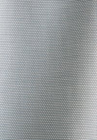 Tessuto blu chiaro caratterizzato da un motivo a griglia, composto da fili intrecciati con una superficie texturizzata e una leggera lucentezza.
