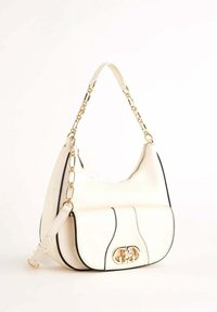Borsa in pelle color crema con manico a catena dorata, tasca frontale con chiusura dorata e dettagli neri lungo i bordi su sfondo bianco.