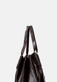 Borsa a tracolla in pelle marrone scuro con superficie texturizzata, dotata di manici intrecciati e forma morbida. Nessuna ferramenta o decorazione visibile.