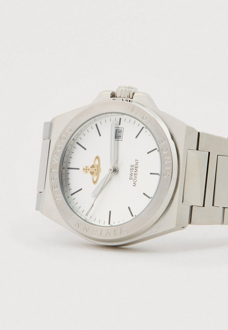 Silberne Armbanduhr aus Edelstahl mit weißem Zifferblatt, schwarzen Stundenmarkierungen, Datumsfenster bei 3 Uhr und Vivienne Westwood Logo unterhalb der 12-Uhr-Position.
