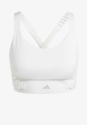 White sports bra with a smooth texture, featuring crisscross straps, adjustable underbust clips, and a subtle logo on the front.