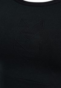 Zwarte sportbeha met een ronde halslijn, voorzien van een textuur met een chevronpatroon aan de voorkant en een gladde, naadloze afwerking.