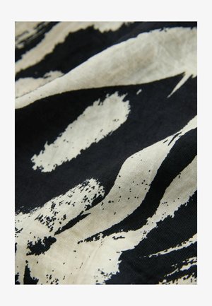 Baumwollstoff mit schwarzem Hintergrund, der große abstrakte beigen Pinselstriche und strukturierte Muster zeigt.