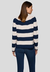 Gestreifter Pullover in Marineblau und Creme mit breitem horizontalem Muster, weicher Textur, langen Ärmeln und lockerer Passform.