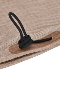 Beige tyg med en texturerad yta har ett svart elastiskt snöre och en plaststopp, placerat längs kanten av materialet.
