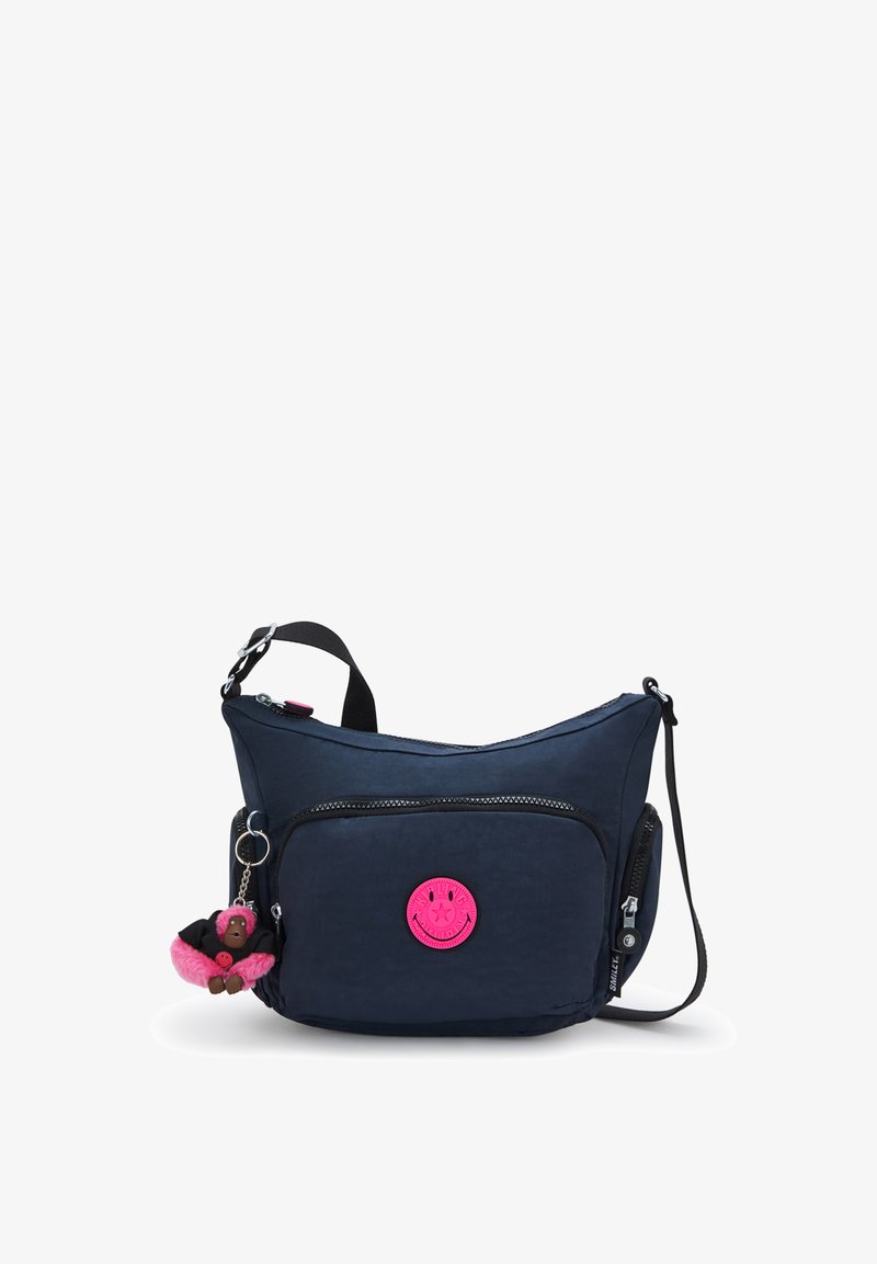 Marineblauwe crossbodytas met voorvak met ritssluiting, roze smiley-patch, zijrits, verstelbare band en pluche roze apensleutelhanger.