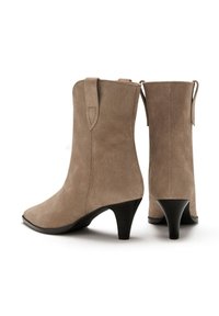 Beige Wildleder-Stiefeletten mit spitzer Zehenpartie und einem 5 cm hohen schwarzen Absatz, mit Zuglaschen an den Seiten für ein einfaches An- und Ausziehen.