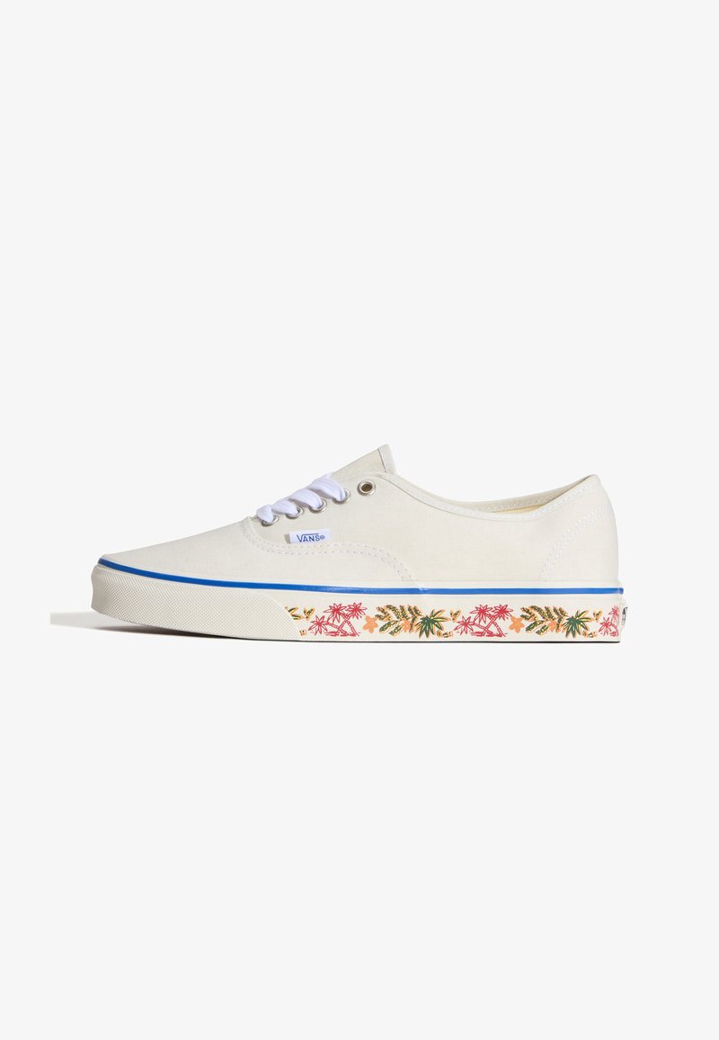 Baskets basses blanches Vans avec lacets blancs et une bande bleue le long de la semelle présentant un motif coloré de plantes tropicales.