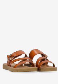 I sandali in pelle marrone presentano due cinturini larghi, una fibbia metallica decorativa e una soletta testurizzata su una suola in gomma beige.