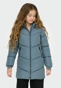 Padded parka jacket in soft gray-blue color, featuring a zip closure, side pockets, and a textured chevron pattern. Long sleeves with ribbed cuffs.