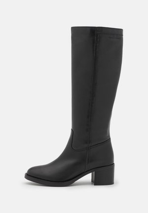 Botte noire en cuir mi-mollet avec talon bloc, couture discrète, design élégant et bout légèrement arrondi.