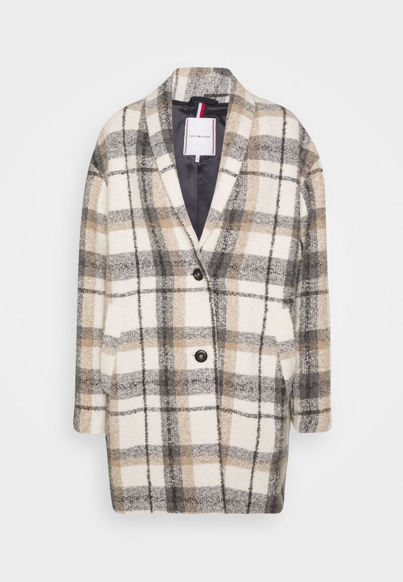 Manteau oversize à carreaux beige, gris et blanc avec deux boutons à l'avant et des poches, doté d'un large col et d'une doublure intérieure noire.