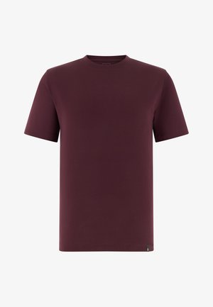 Prosty krótki rękaw, koszulka z okrągłym dekoltem w ciemnym bordo z małą czarną metką na dolnym brzegu po lewej stronie.