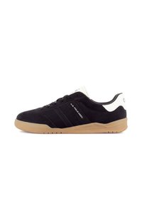 Basket basse noir et blanc avec semelle couleur noisette, bandes latérales et marquage "U.S. Polo Assn." sur le panneau latéral.