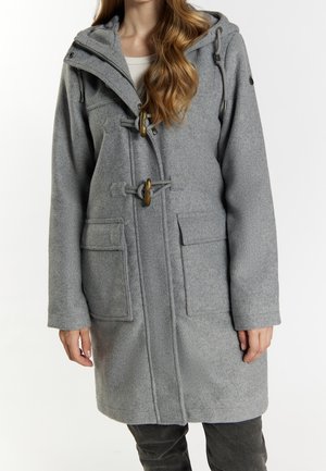 Kobieta nosząca szary, wełniany płaszcz do kolan z zapięciami na pętelki, dużymi przednimi kieszeniami i kapturem na jasnym topie.