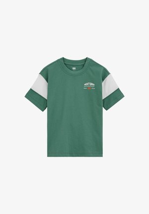 Zöld rövid ujjú póló fehér ujj díszítéssel és "NEXT GRID" felirattal a bal mellkason.