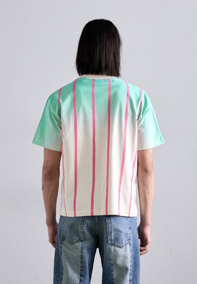 Green and cream cotton t-shirt with vertical pink stripes. Short sleeves and a round neckline, featuring a relaxed fit and smooth texture.