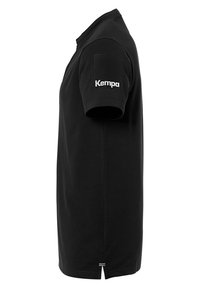 Black short-sleeve polo shirt made of cotton, featuring a printed white "Kempa" logo on the left sleeve and a split hem at the bottom.