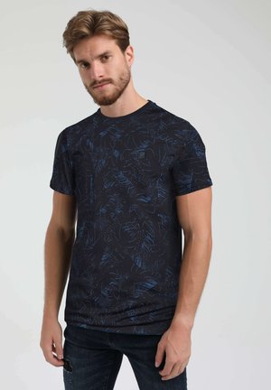 Schwarzes T-Shirt mit einem blauen abstrakten Muster. Kurze Ärmel, runder Halsausschnitt, aus weichem Stoff mit einer leicht taillierten Form.