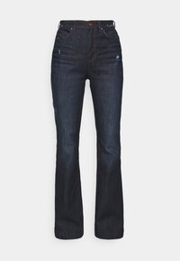 Mörkblå denimjeans med rak ben-design, kontrasterande sömmar och slitna detaljer nära fickorna. Standard femficksdesign.