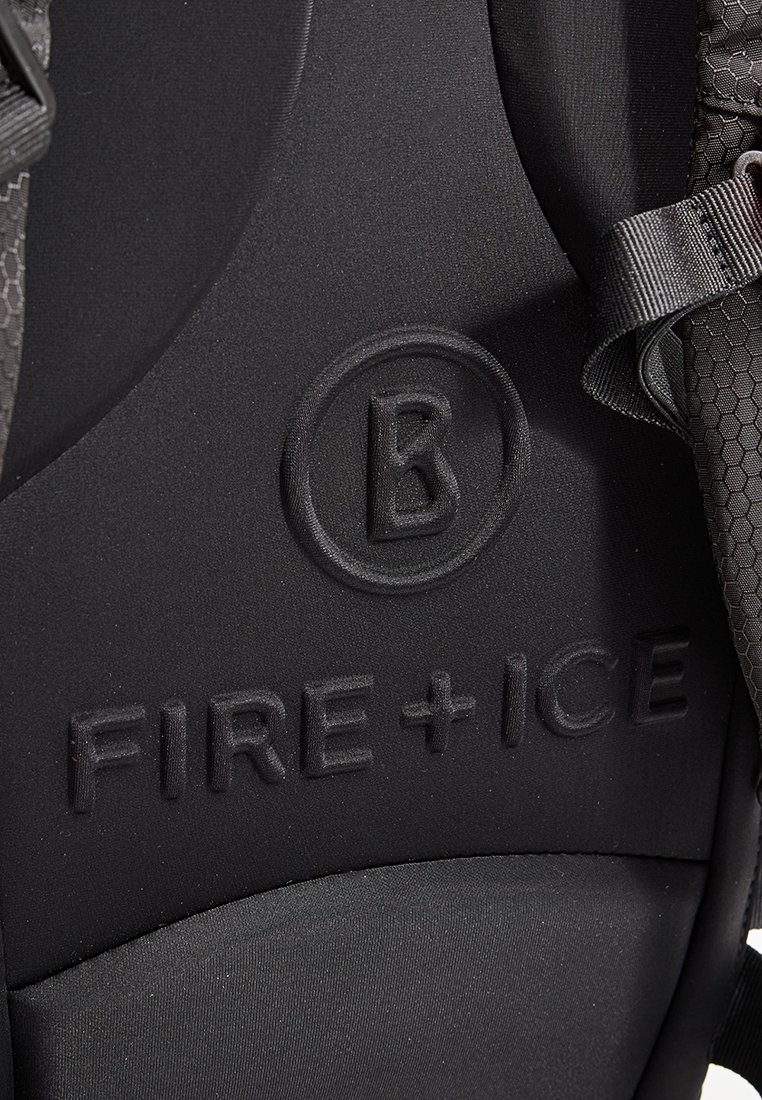 Nahaufnahme eines schwarzen Rucksacks mit geprägtem "FIRE + ICE"-Text und kreisförmigem Logo mit einem stilisierten "B" in der Nähe der strukturierten Riemen.