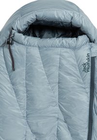 Lichtblauwe donsjas met een gestikt patroon, verstelbare kraag en zijrits. Kenmerkt het merklogo "Jack Wolfskin" aan de voorkant.