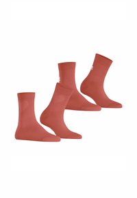 Drei Paar knöchellange Socken in einem gedämpften Terrakotta-Farbton, mit gerippten Mustern und einem kleinen Logo an der Seite. Weiches, nahtloses Design.