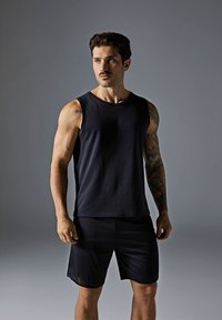 Black sleeveless athletic tank top and matching shorts. The fabric is smooth, with a fitted design and a subtle texture on the shorts.