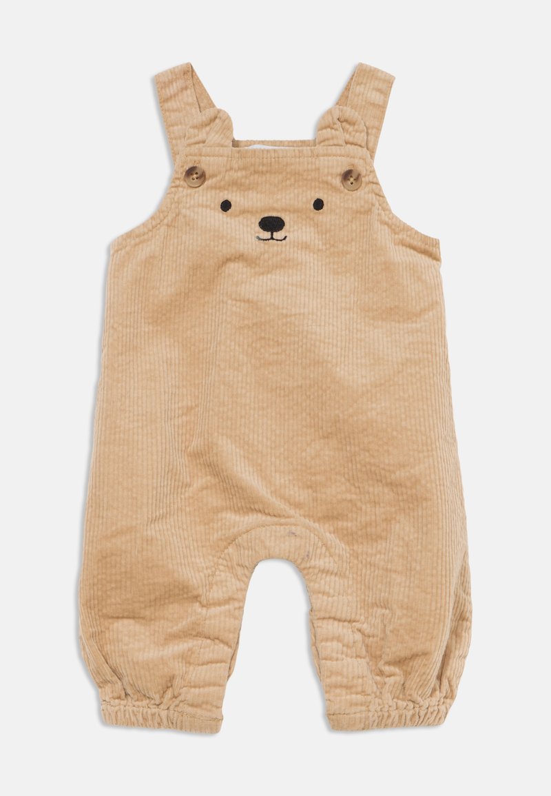 Combinaison bébé en velours côtelé beige avec bretelles, boutons en bois, chevilles élastiquées et un visage d’ours brodé sur la poitrine.
