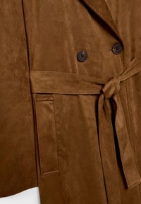 Manteau en daim marron avec ceinture nouée, deux boutons foncés et une poche fendue verticale à gauche.