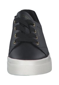 Black leather sneaker with flat white rubber sole, round toe, gold eyelets, and black laces. Features embossed brand logo on tongue.