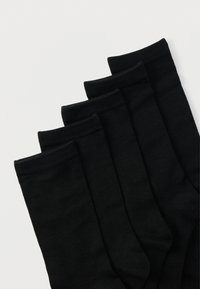 Meias pretas de algodão num pack de cinco, com punho canelado e textura suave. Cada par é uniformemente escuro, sem padrões.