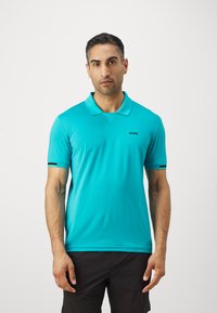 Turkizna polo majica s klasičnim ovratnikom, kratkim rukavima in črnim logotipom na prsih. Ima kontrastne poudarjene črte.