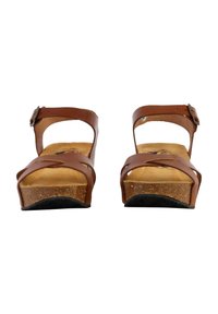 Sandali wedge in pelle marrone con sottopiede in sughero, fasce incrociate e una fibbia regolabile alla caviglia, con una suola in gomma nera testurizzata.