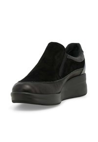 Scarpa nera slip-on realizzata in una combinazione di pelle liscia e suede texture, con una suola piattaforma imbottita e rialzata.
