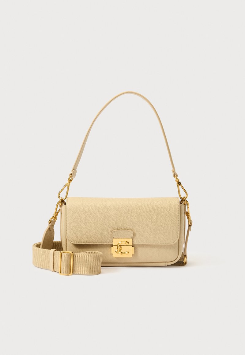 Sac à main en cuir beige avec une finition texturée, des éléments en métal doré, une fermeture à rabat et une bandoulière amovible en toile. Forme rectangulaire compacte.