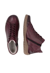 Paire de chaussures montantes en cuir bordeaux avec semelles marron, lacets devant et fermeture éclair latérale sur fond blanc.