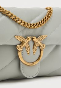 Τσάντα από ανοιχτό γκρι δέρμα με κεντητό σχέδιο, με χρυσή αλυσίδα ιμάντα και χρυσό κούμπωμα με δύο πουλιά που κοιτάζουν το ένα το άλλο.