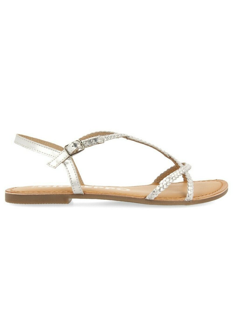 Sandalia de cuero blanco con correas trenzadas, cierre de hebilla y suela plana y texturizada. Diseño de punta abierta y estética minimalista.