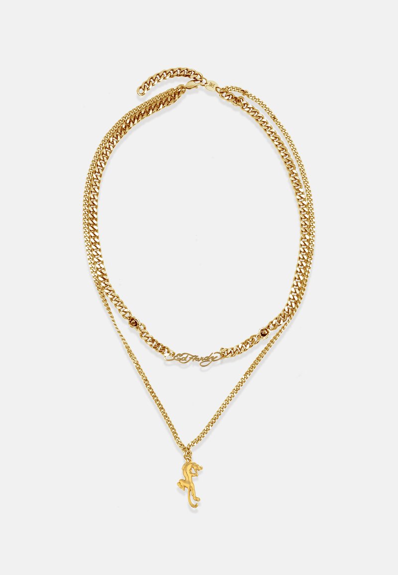 Złoty naszyjnik z warstwowymi łańcuszkami i charmem w kształcie jaszczurki oraz eleganckim, kursywnym akcentem; gładka tekstura, błyszczące wykończenie, wiele stylów ogniw.