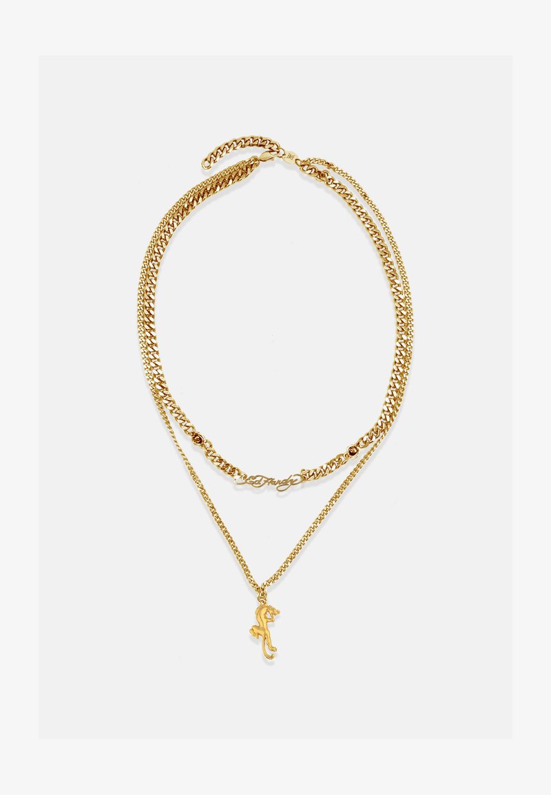 Złoty naszyjnik z warstwowymi łańcuszkami i charmem w kształcie jaszczurki oraz eleganckim, kursywnym akcentem; gładka tekstura, błyszczące wykończenie, wiele stylów ogniw.