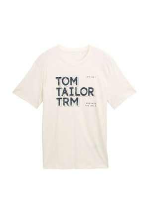 Šviesiai kremas spalvos medvilnės marškinėliai trumpomis rankovėmis. Su grafiniu tekstu "TOM TAILOR" ir "EMBRACE THE WILD" tamsiai mėlyna spalva. Standartinio kirpimo.
