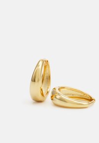 Orecchini a cerchio in oro con un design liscio e arrotondato. Presentano una finitura metallica lucida e una leggera curvatura nel punto di chiusura.