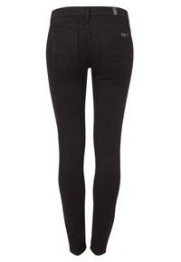 Pantalones vaqueros skinny negros con una textura suave, cintura de altura media y dos bolsillos traseros. Presentan costuras sutiles y una etiqueta de marca en la cinturilla.