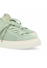 Baskets vert clair au design en mesh avec des lacets assortis. Présente une semelle en caoutchouc beige et un petit logo doré sur la languette.