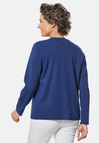 Crewneck-Pullover in sattem Blau, aus weichem Stoff gefertigt. Verfügt über lange Ärmel und eine lockere Passform. Die Rückseite ist schlicht und hat keine zusätzlichen Details.