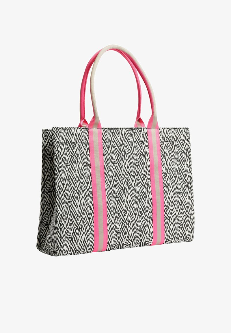 Sac fourre-tout à motif zigzag noir et blanc avec deux anses rayées rose et beige et des rayures verticales sur le devant.